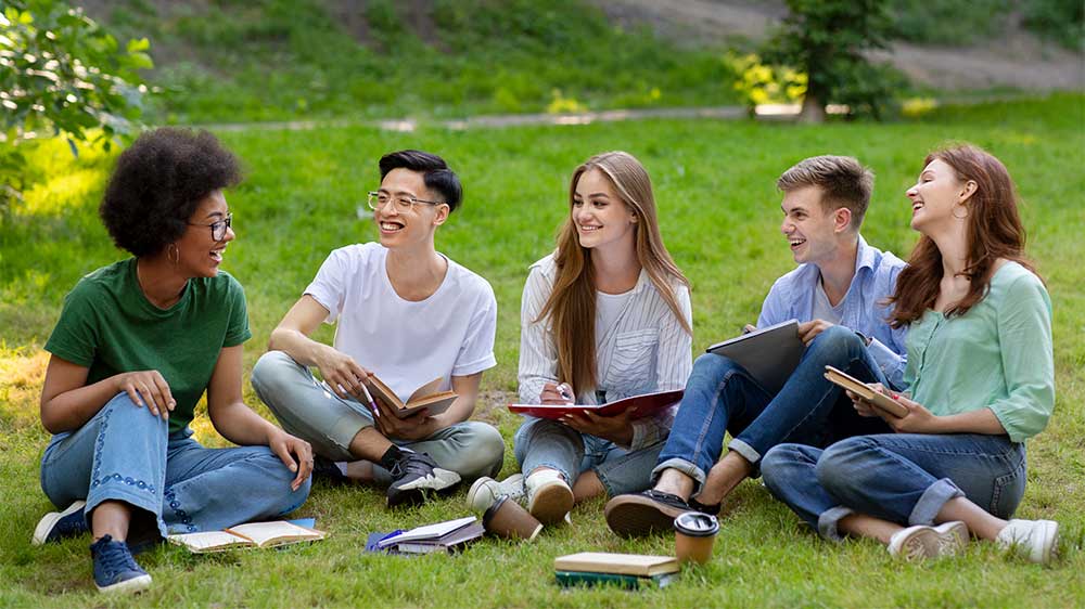 group of university students studying on lawn