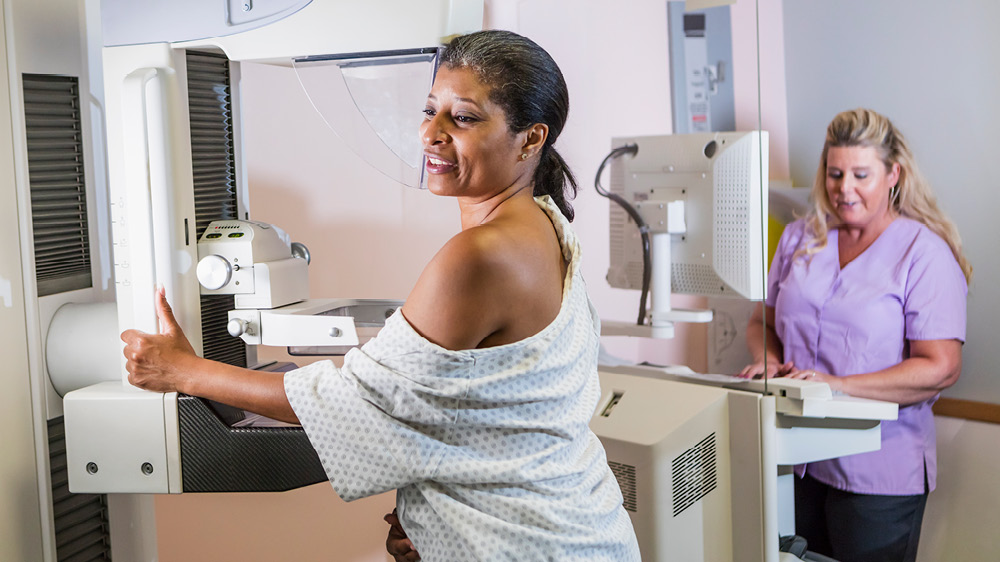 Black woman receiving mammogram