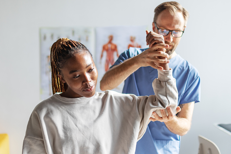 Patient's shoulder being examined by doctor
